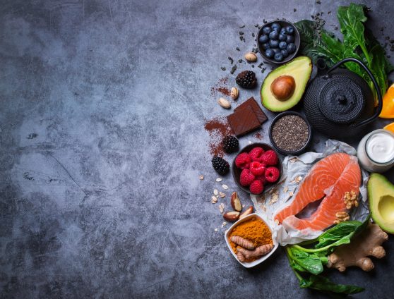 Assortment of healthy feel good food, superfood ingredients for stress, anxiety, chronic fatigue, depression relieving, reducing, for relaxation on a kitchen table. Top view flat lay background